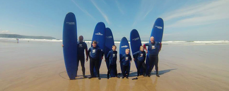 family surfing on saunton beach in devon